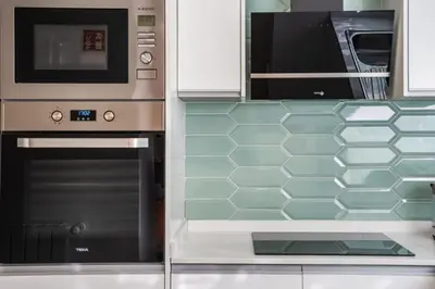 a kitchen with a stove and a microwave at AGUIAR´S VILLAGE in Ribeira Brava