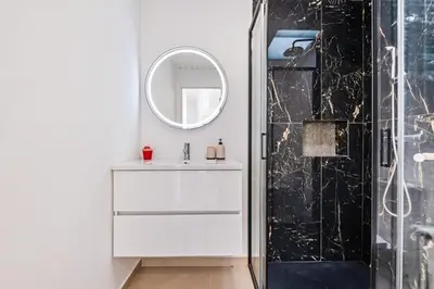 a bathroom with a white sink and a mirror at AGUIAR´S VILLAGE in Ribeira Brava