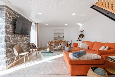 a living room with an orange couch and a table at AGUIAR´S VILLAGE in Ribeira Brava