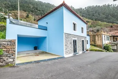 a blue and white house with a garage at AGUIAR´S VILLAGE in Ribeira Brava