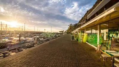 a sidewalk next to a marina with tables and chairs at Typical House -Madeira Inn Group in Calheta