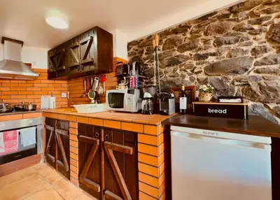 a kitchen with a counter and a stone wall at Typical House -Madeira Inn Group in Calheta
