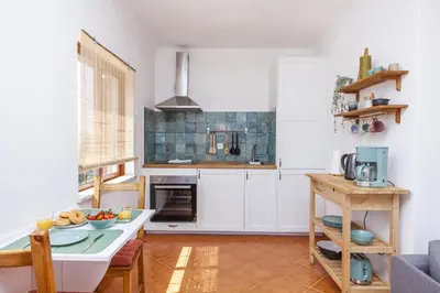 a kitchen with white cabinets and a table at A56 - Westway Rossio Holiday Place in Luz