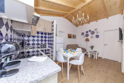 a kitchen and dining room with a white table and chairs at B54 - Casa Azul in Burgau in Budens
