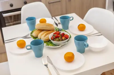 a table with a plate of bread and a bowl of fruit at B54 - Casa Azul in Burgau in Budens