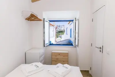 a small room with two beds and a window at B54 - Casa Azul in Burgau in Budens