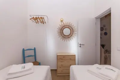 a room with two beds and a mirror on the wall at B54 - Casa Azul in Burgau in Budens