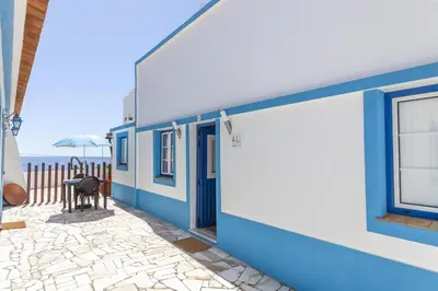 a blue and white building with the ocean in the background at B54 - Casa Azul in Burgau in Budens