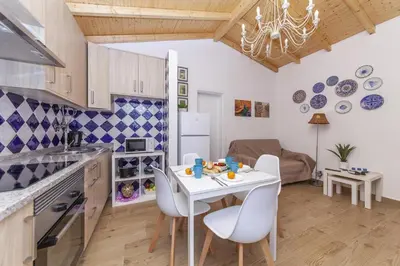 a kitchen and dining room with a white table and chairs at B54 - Casa Azul in Burgau in Budens