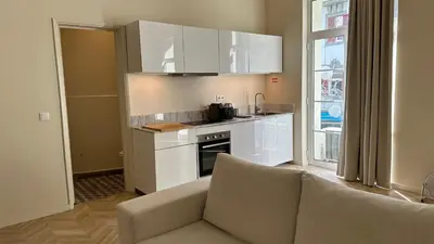 a kitchen with white cabinets and a couch in a room at Downtown collection apartments in Funchal
