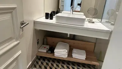 a bathroom with a sink and a mirror and towels at Downtown collection apartments in Funchal