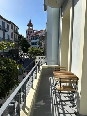 a balcony with two chairs and a table on a building at Downtown collection apartments in Funchal