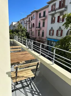 two wooden tables and chairs on a balcony with buildings at Downtown collection apartments in Funchal