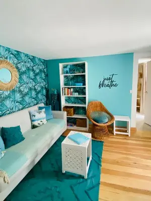 a living room with a couch and a blue wall at CASA BOHO your happy place in Calheta in Calheta