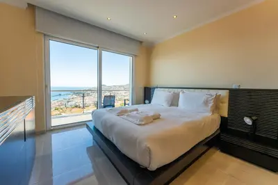 a bedroom with a large bed with a large window at FLH Funchal House with Sea View in Funchal