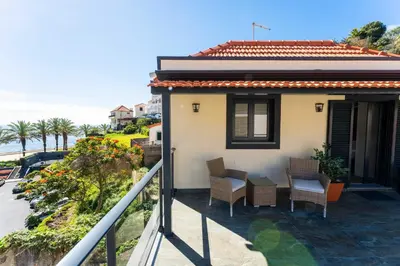 a balcony of a house with chairs and the ocean at FLH Santa Cruz Triplex with Terrace in Santa Cruz