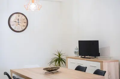 a dining room with a table and a clock on the wall at FLH Santa Cruz Triplex with Terrace in Santa Cruz
