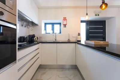 a kitchen with white cabinets and black appliances at FLH Santa Cruz Triplex with Terrace in Santa Cruz