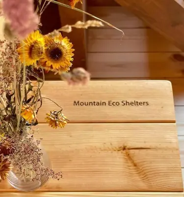 a vase filled with flowers on a wooden table at Mountain Eco Shelter 8 in Funchal