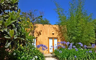 a living room with windows and a desk with a laptop at Casa dos Sonhos, private terrace, quiet location, walking to village, ecological pool, pets considered, nature friendly in Barão de São João