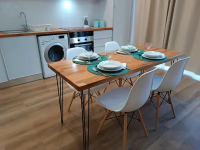 a dining room table with chairs and a kitchen at Kings B&B Santa Cruz in Santa Cruz