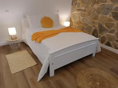 a bedroom with a bed with a stone wall at Kings B&B Santa Cruz in Santa Cruz