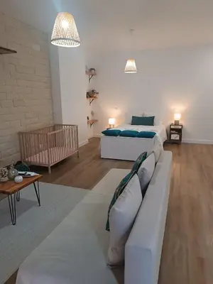 a living room with a white couch and a bed at Kings B&B Santa Cruz in Santa Cruz