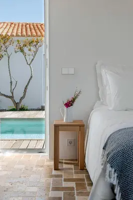 a bedroom with a bed and a view of a pool at Sanderling beach & dune house in Carrapateira