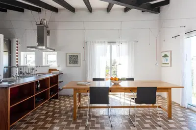 a kitchen with a wooden table and chairs at Sanderling beach & dune house in Carrapateira