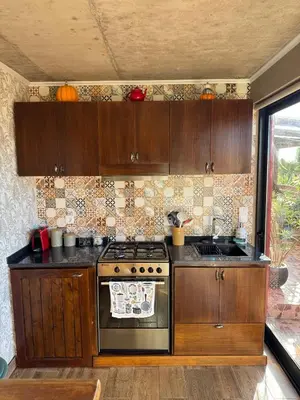 a kitchen with wooden cabinets and a stove at Victoria Ocean View Room in Ponta do Pargo