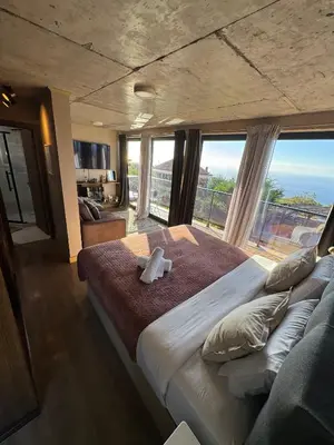 a bedroom with a large bed with a large window at Victoria Ocean View Room in Ponta do Pargo