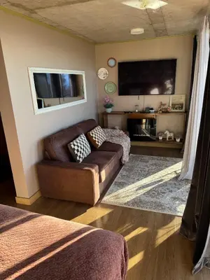a living room with a couch and a flat screen tv at Victoria Ocean View Room in Ponta do Pargo