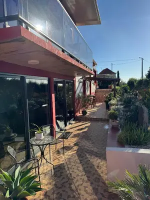 a patio of a building with a table and chairs at Victoria Ocean View Room in Ponta do Pargo