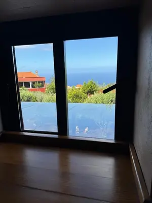 a window with a view of the water outside at Victoria Tiny Stone House in Ponta do Pargo