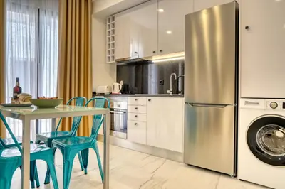 a kitchen with a table and a stainless steel refrigerator at Beco Santa Emilia 2F, a Home in Madeira in Funchal
