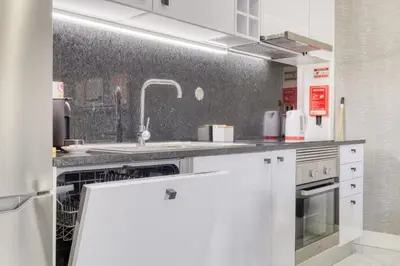 a kitchen with white cabinets and a sink at Beco Santa Emilia 3M, a Home in Madeira in Funchal