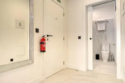 a white bathroom with a fire extinguisher on the wall at Beco Santa Emilia 3M, a Home in Madeira in Funchal