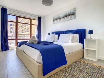 a bedroom with a blue and white bed and a window at Ocean Breeze by LovelyStay in Funchal