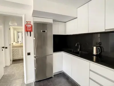 a kitchen with white cabinets and a stainless steel refrigerator at Ocean Breeze by LovelyStay in Funchal