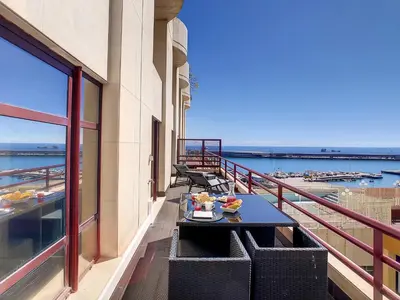a balcony with a table and chairs with a view of the water at Ocean Breeze by LovelyStay in Funchal