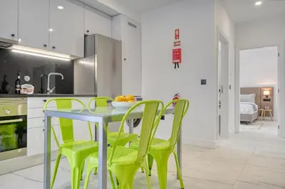 a kitchen with a table and green chairs at Beco Santa Emilia 3J, a Home in Madeira in Funchal