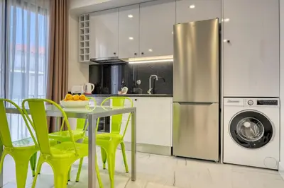 a kitchen with a table with yellow chairs and a refrigerator at Beco Santa Emilia 3J, a Home in Madeira in Funchal
