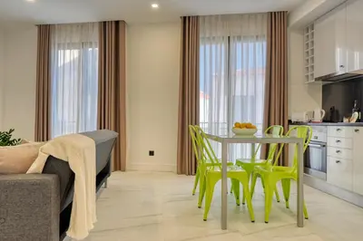 a kitchen and dining room with a table and chairs at Beco Santa Emilia 3J, a Home in Madeira in Funchal