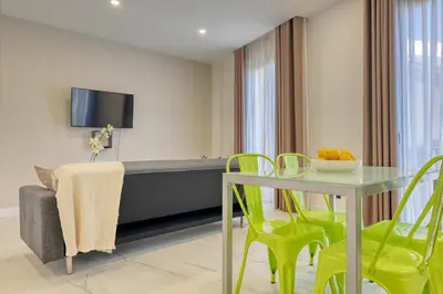a living room with a table and green chairs at Beco Santa Emilia 3J, a Home in Madeira in Funchal