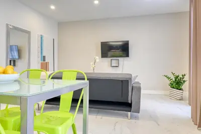 a living room with a table and chairs and a tv at Beco Santa Emilia 3J, a Home in Madeira in Funchal