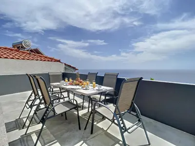 a table and chairs on a balcony with the ocean at Villa Formosa View by Atlantic Holiday in Funchal
