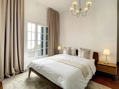 a white bedroom with a large bed and a chandelier at Villa Formosa View by Atlantic Holiday in Funchal