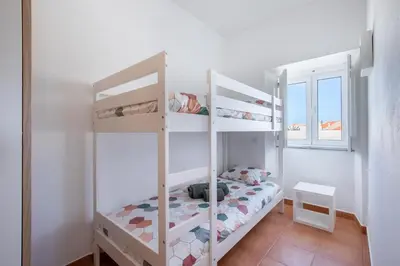 a bedroom with two bunk beds and a window at Casa 7 Gerações in Sagres