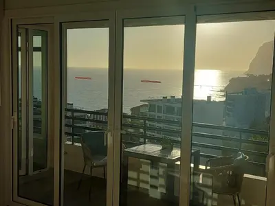 a view of the ocean from a balcony with a table and chairs at Horizon Dream in Funchal