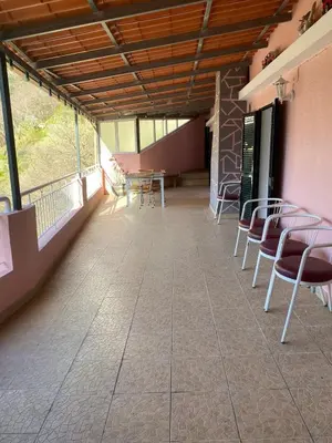 a room with chairs and tables and windows at Vivenda Ribeiro - Curral das Freiras in Curral das Freiras
